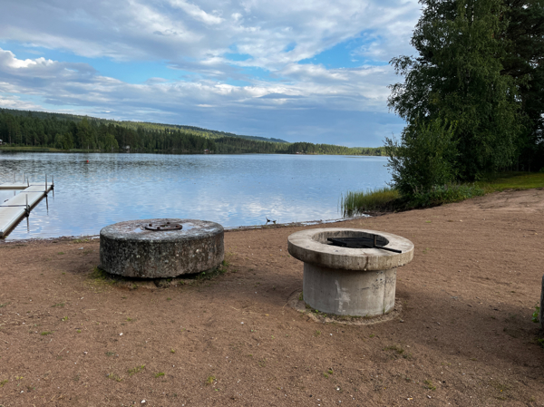 Eldstad av betong nära vattnet