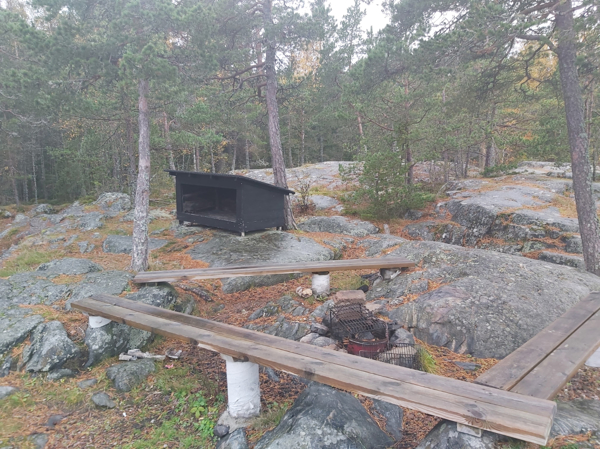 Grillplatsen med vedförrådet i bakgrund