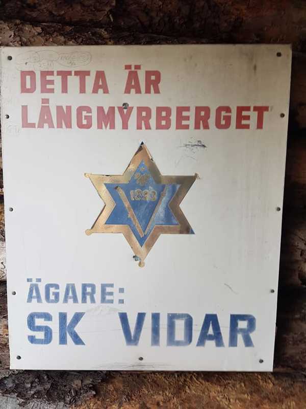 Skylt sitter på vindskyddet om Långmyrberget, ägare SK Vidar