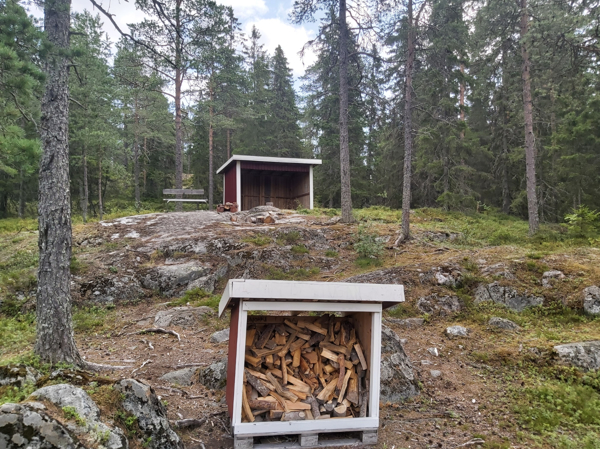 Vedförrådet med vindskyddet i bakgrund